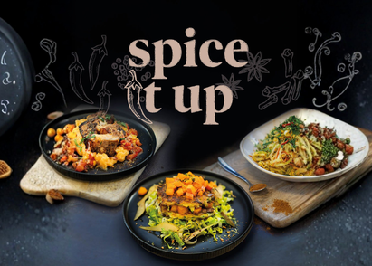 Drei Gerichte aus der neuen Kampagnenreihe "Spice it up" der Compass Group. Die Gerichte sind schön angerichtet mit Gewürzen. Über den drei Tellern steht der Schriftzug "Spice it up" und ein paar Gewürze als Icons (Zimt, Nelken, Chilli).
