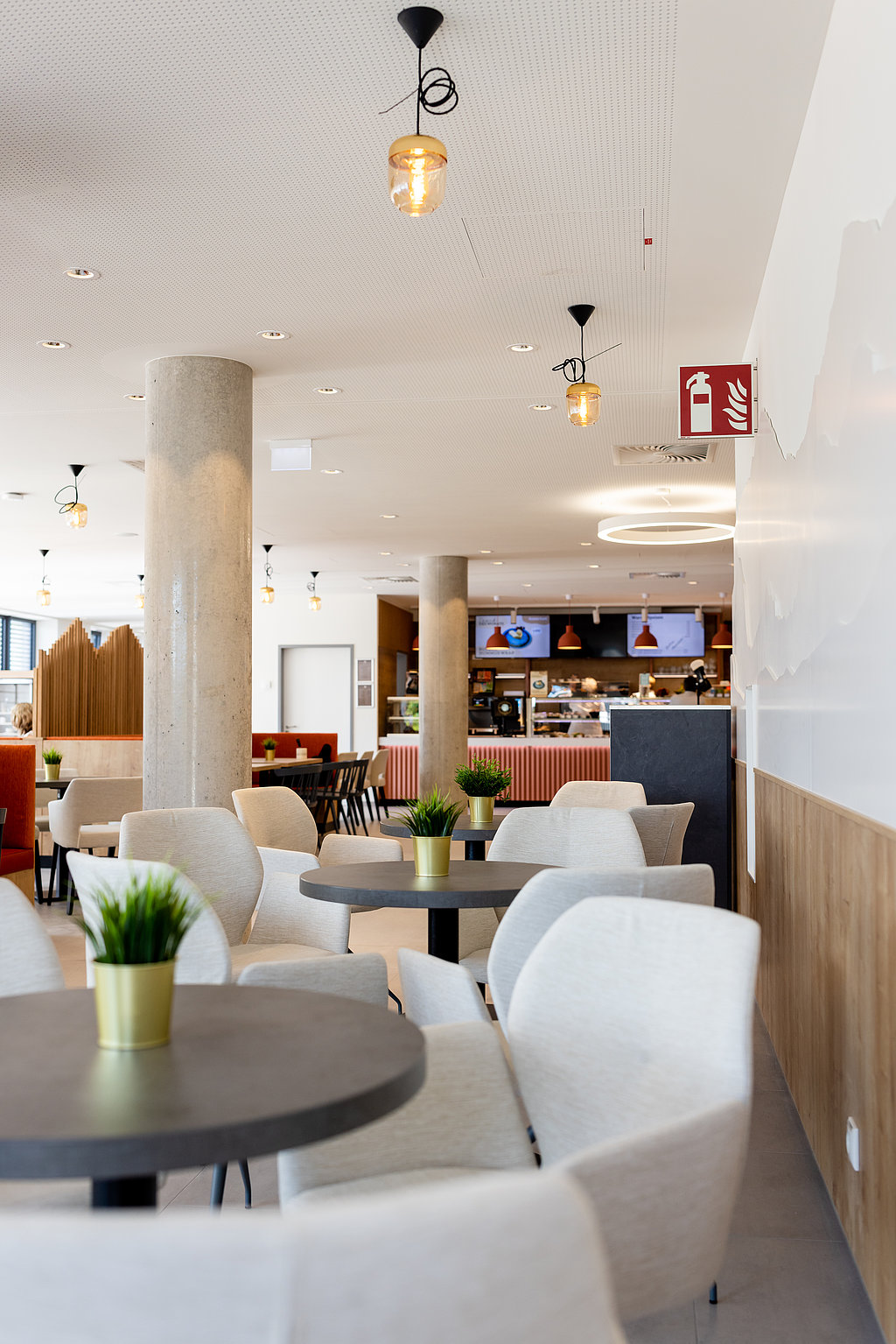 Ein gemütliches, hell, gestaltetes Cafe mit netten in beige gehaltenen Sitzecken.