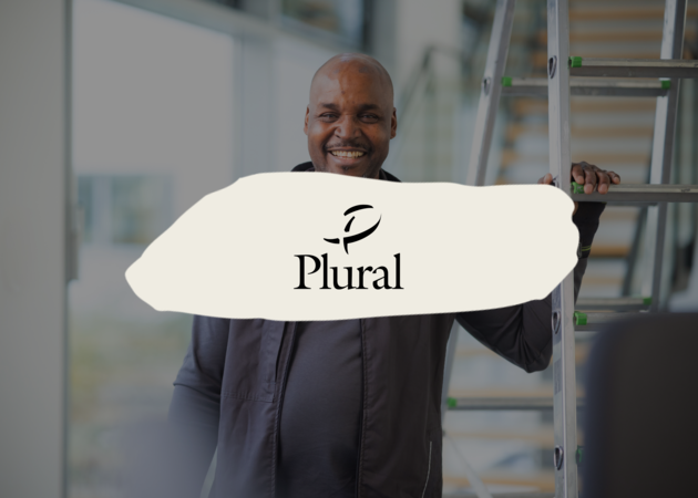 PLURAL Ein Hausmeister, der freundlich in die Kamera lächelt und sich mit einer Hand an einer Stehleiter anlehnt. Darüber ist das Logo der Facility Management Marke PLURAL der Compass Group zu sehen.