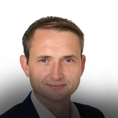 Ein junger Mann in Sakko und weißem Hemd.