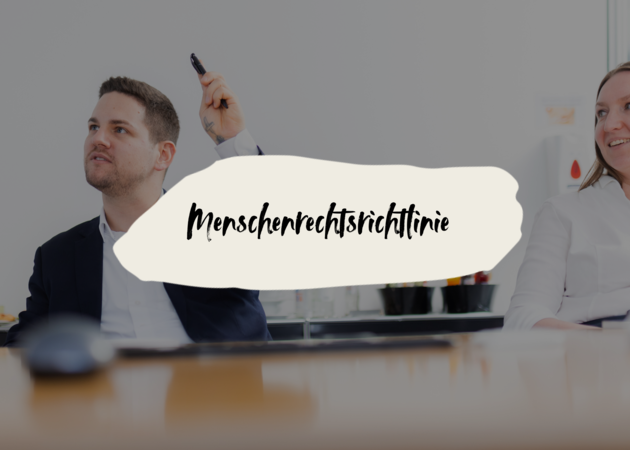 Ein junger Mann und eine junge frau, die an einem Tisch sitzen und im Meetingraum etwas diskutieren. Der junge Mann hebt die Hand und zeigt auf.