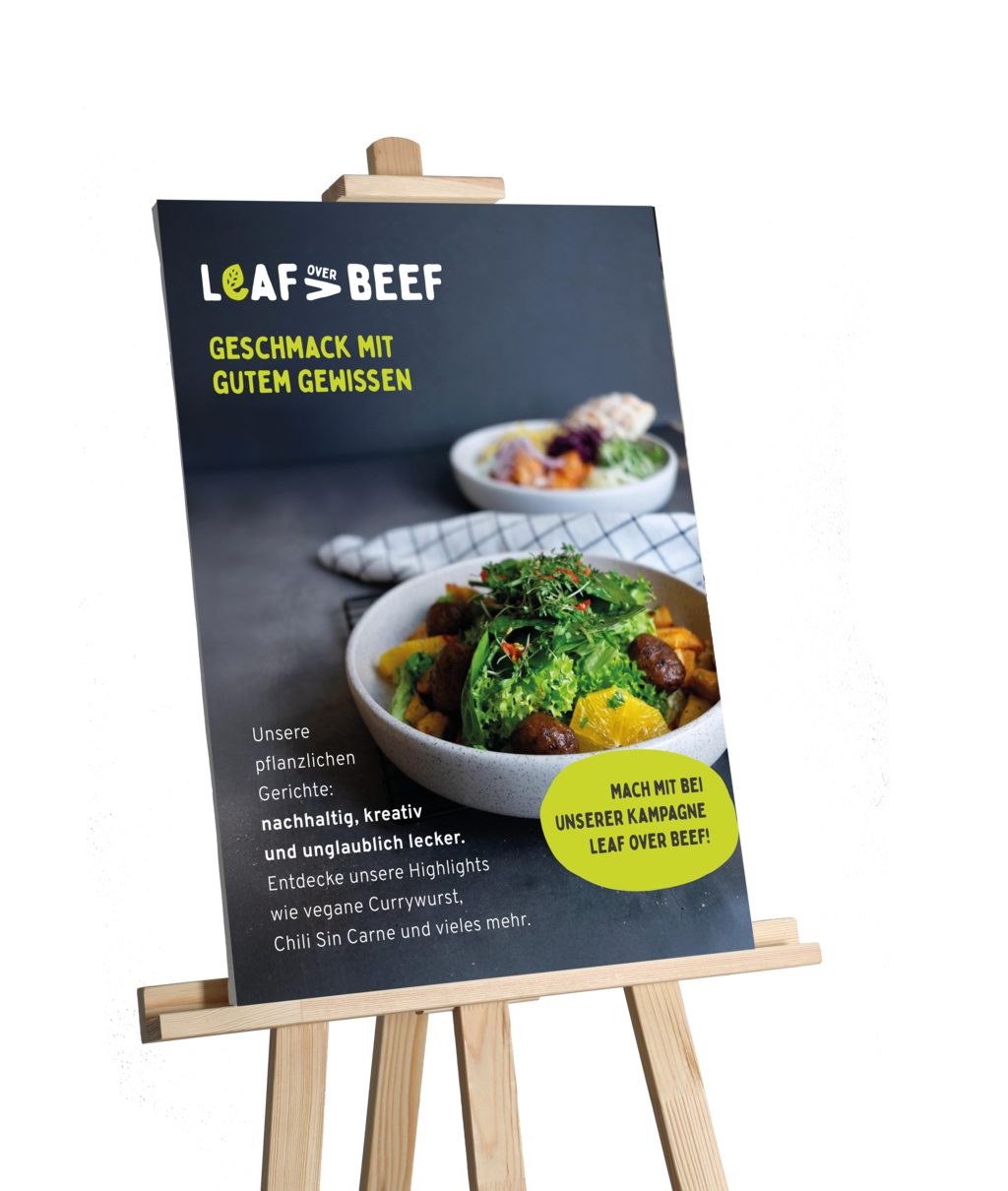 Ein Mock-up, das eine Staffelei zeigt, auf der ein Werbeplakat zu unserer Kampagne Leaf over Beef zu sehen ist. Auf dem Plakat ist ein veganes Gericht abgebildet.