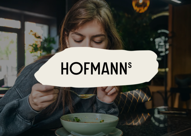 Eine junge Frau, die eine Suppe isst.