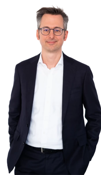 Eine männliche Führungskraft (der CEO), im Anzug, die freundlich in die Kamera lächelt.
