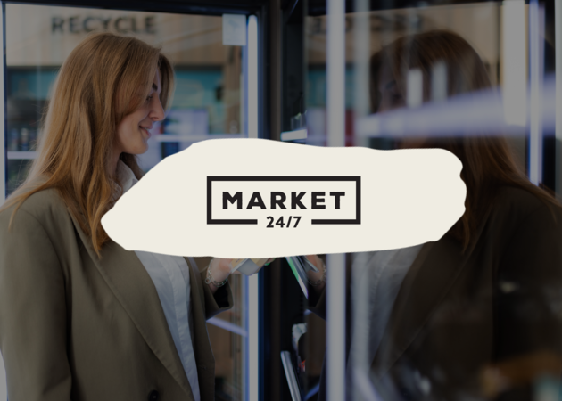 Eine junge Frau die den Kühlschrank zu einem Micromarkt öffnet, um ein Gericht herauszunehmen. Davor ist das Logo der Compass Group Retailmarke Market 24/7 zu sehen.