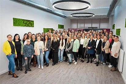 Eine Gruppe von Personen, die freundlich in die Kamera lächeln.