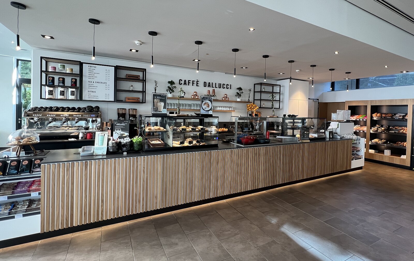 Eine Kaffeebar, die mit hellem Holz verkleidet ist und sehr einladend aussieht.
