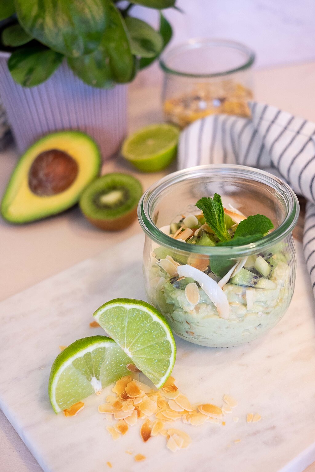Ein Kiwi Birchermüsli mit Mandeln im Glas.