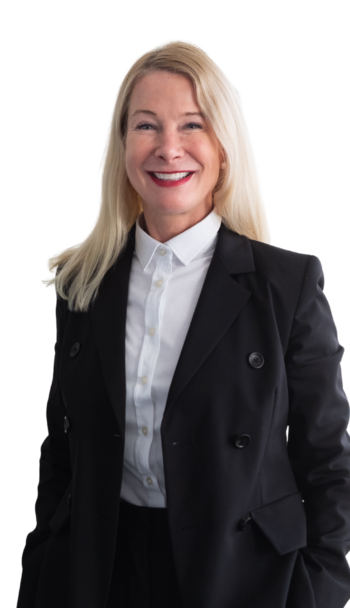 Eine weibliche Führungskraft mit Blazer und Bluse. Sie lächelt freundlich in die Kamera.