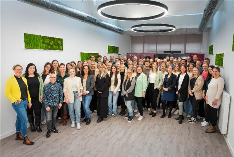 Eine Gruppe von Personen, die freundlich in die Kamera lächelt. 